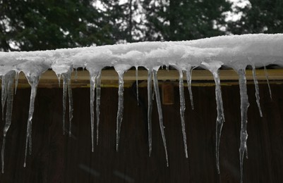 House with icicles on roof. Winter season