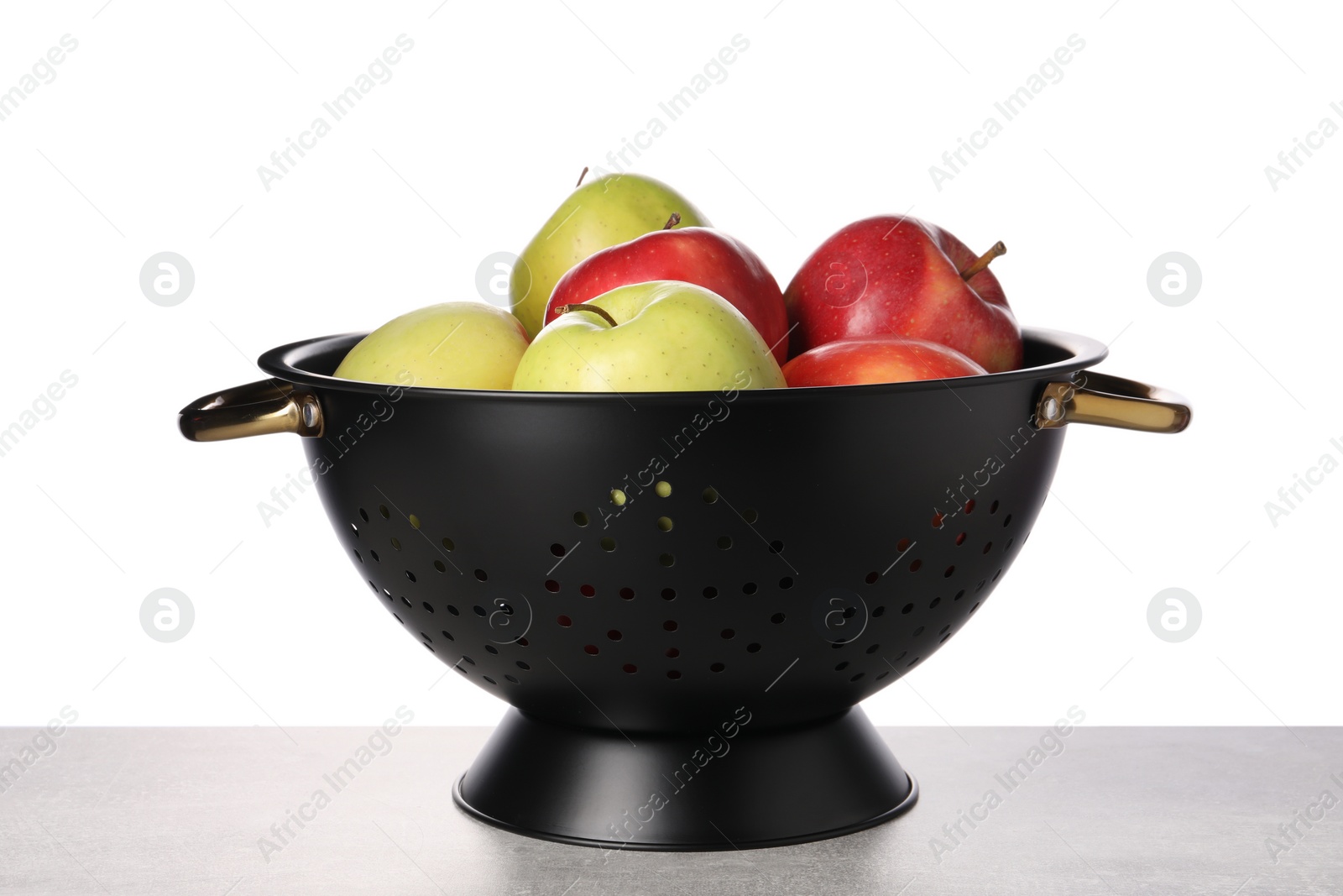 Photo of Fresh apples in colander on table against white background