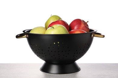 Photo of Fresh apples in colander on table against white background