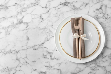 Beautiful table setting on white marble background, flat lay. Space for text