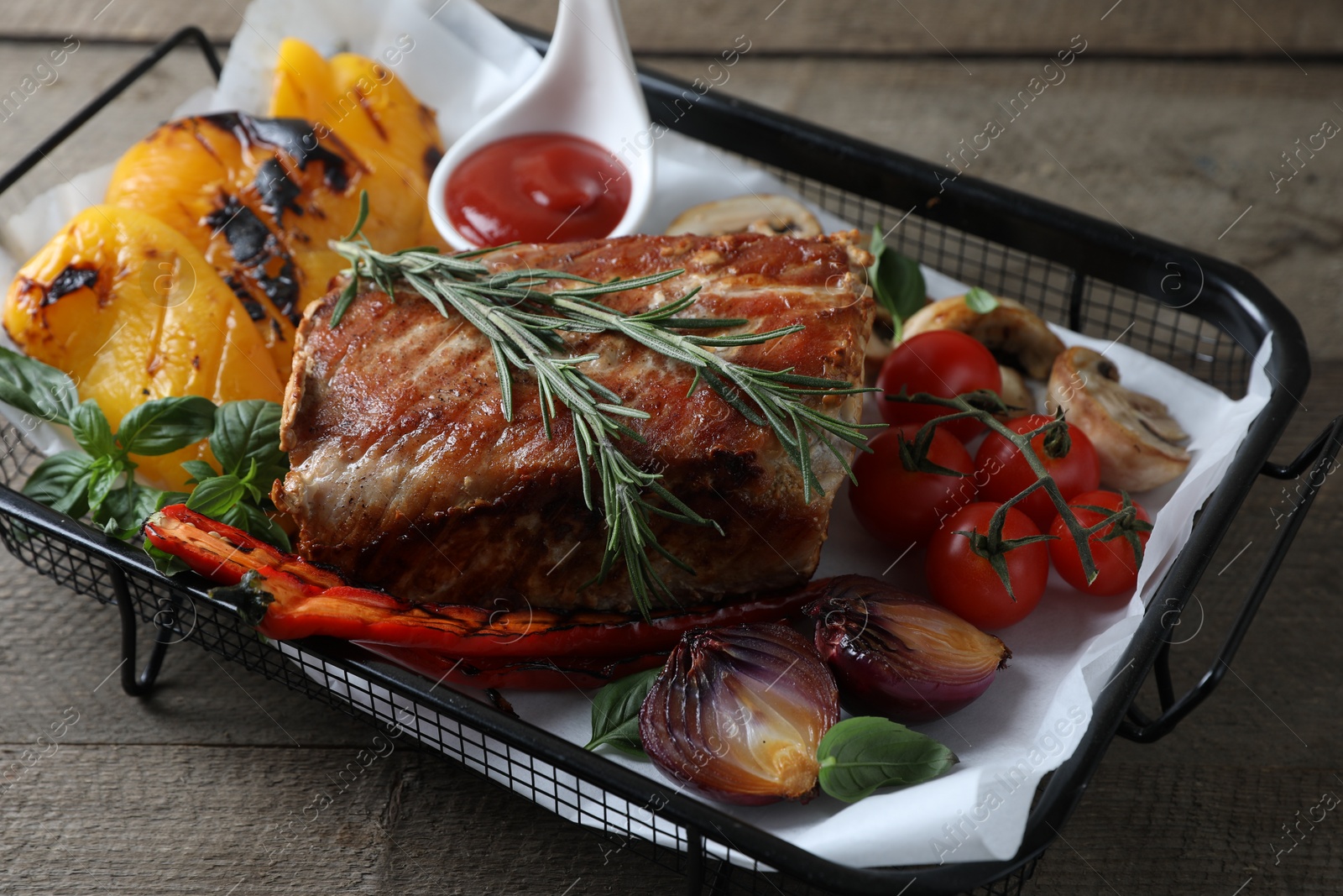 Photo of Delicious grilled meat and vegetables served with sauce on wooden table, closeup