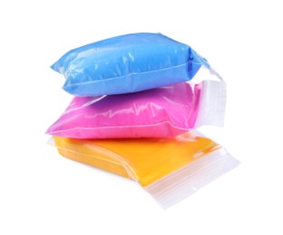 Packages of different colorful plasticine on white background