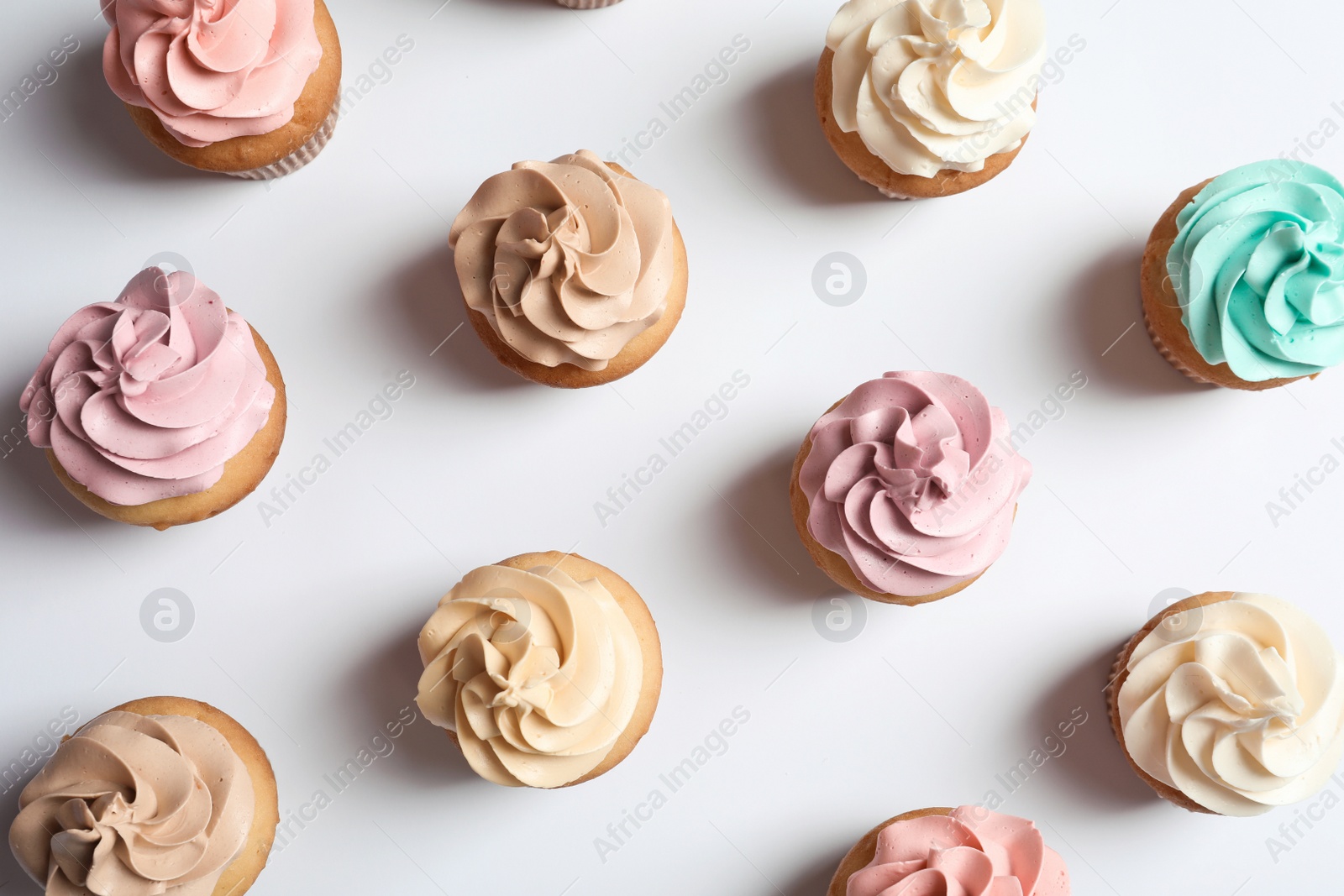 Photo of Flat lay composition with delicious birthday cupcakes on white background