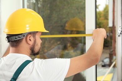 Photo of Construction worker installing new window in house