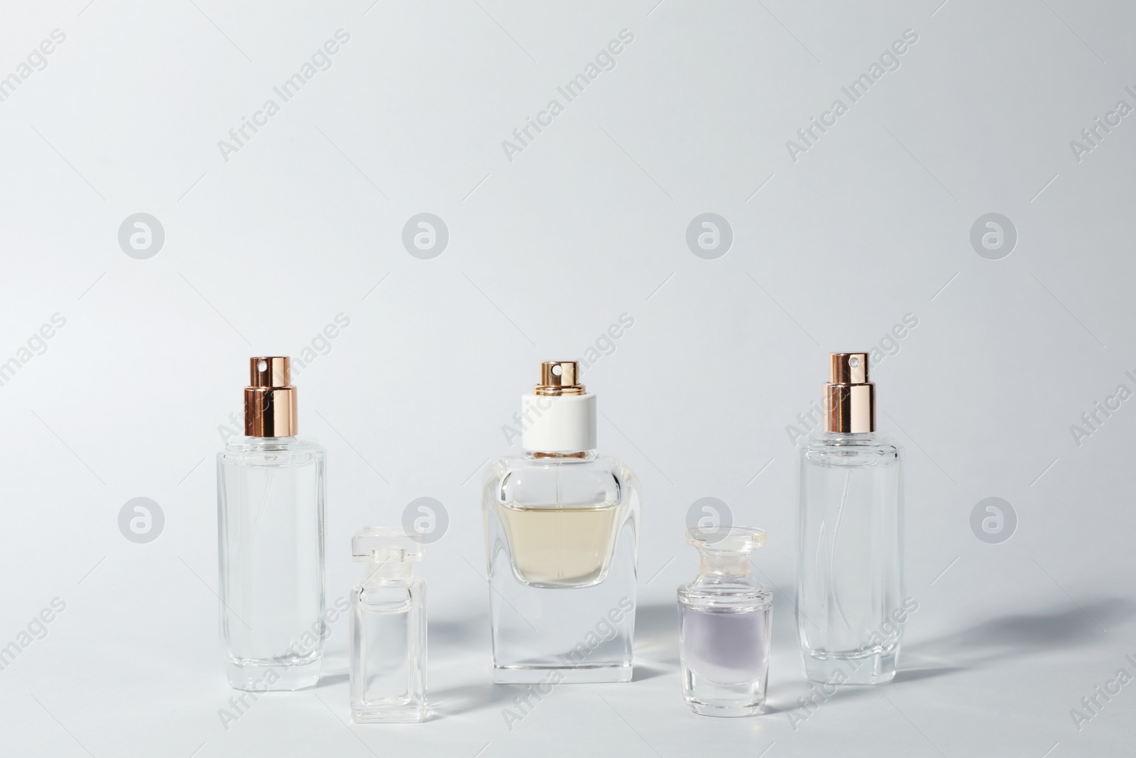 Photo of Bottles of perfume on light background