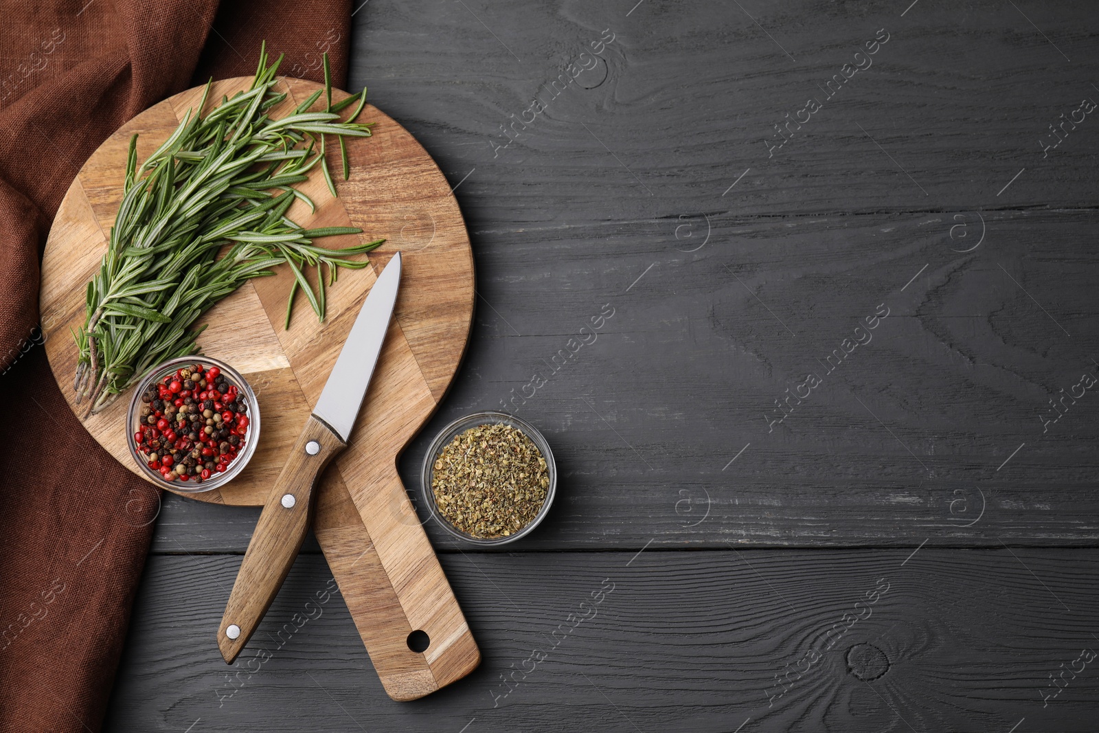 Photo of Wooden board, knife and spices on grey table, flat lay. Space for text