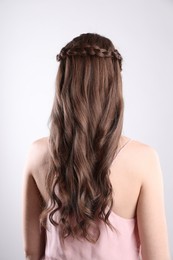 Photo of Woman with braided hair on light background, back view