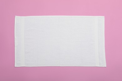 Photo of White beach towel on pink background, top view