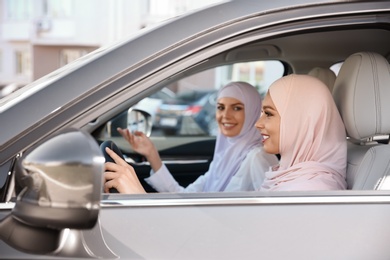 Female Muslim driver and her friend in car