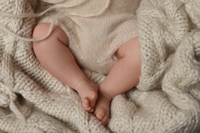 Photo of Top view of cute newborn baby on knitted blanket, closeup