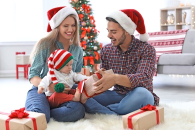 Happy couple with baby celebrating Christmas together at home