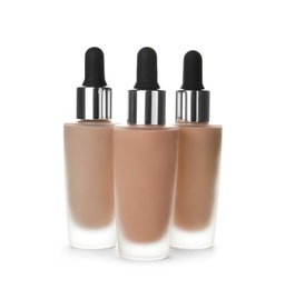 Photo of Bottles of different skin foundations on white background