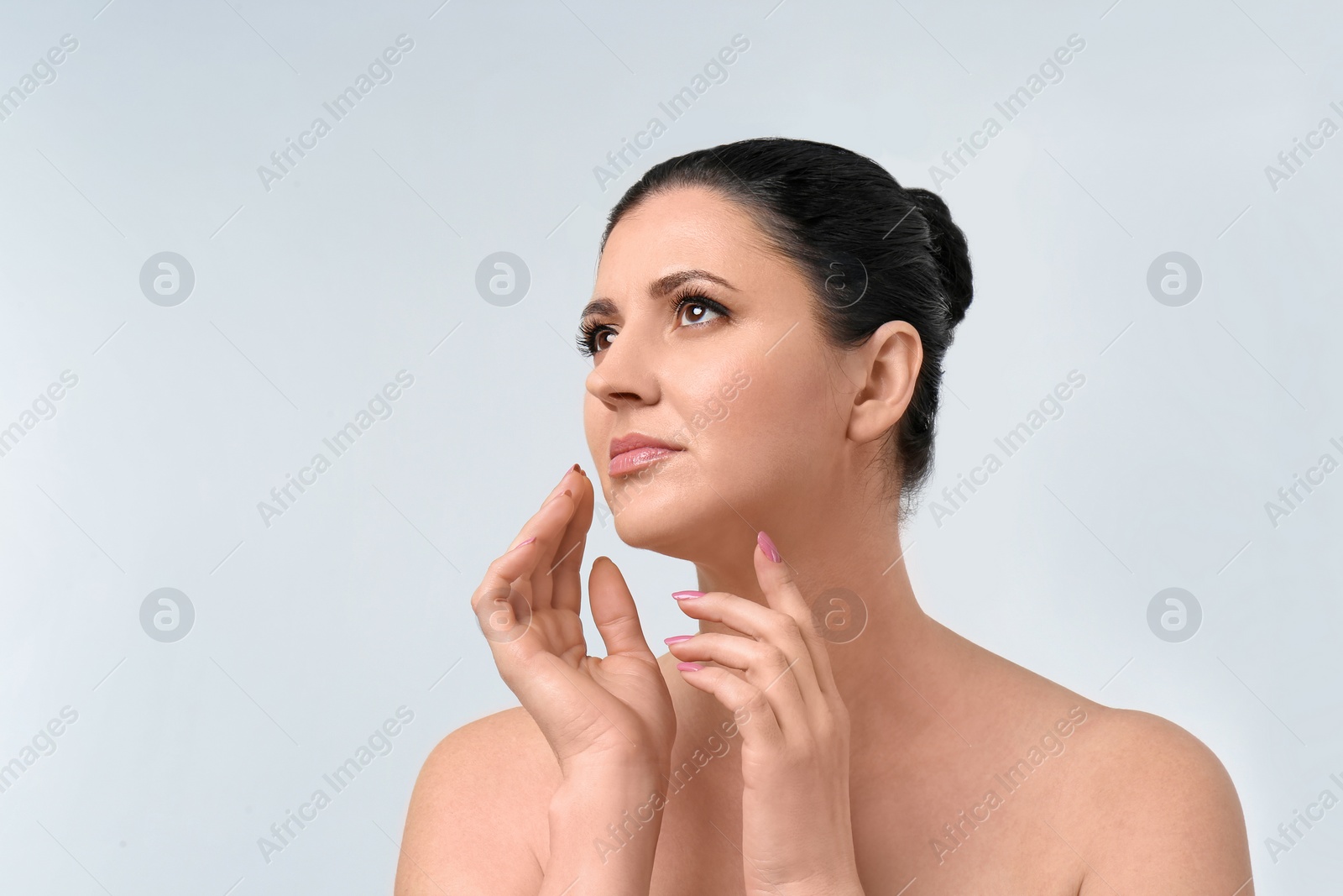 Photo of Beautiful woman with clean perfect skin on light background