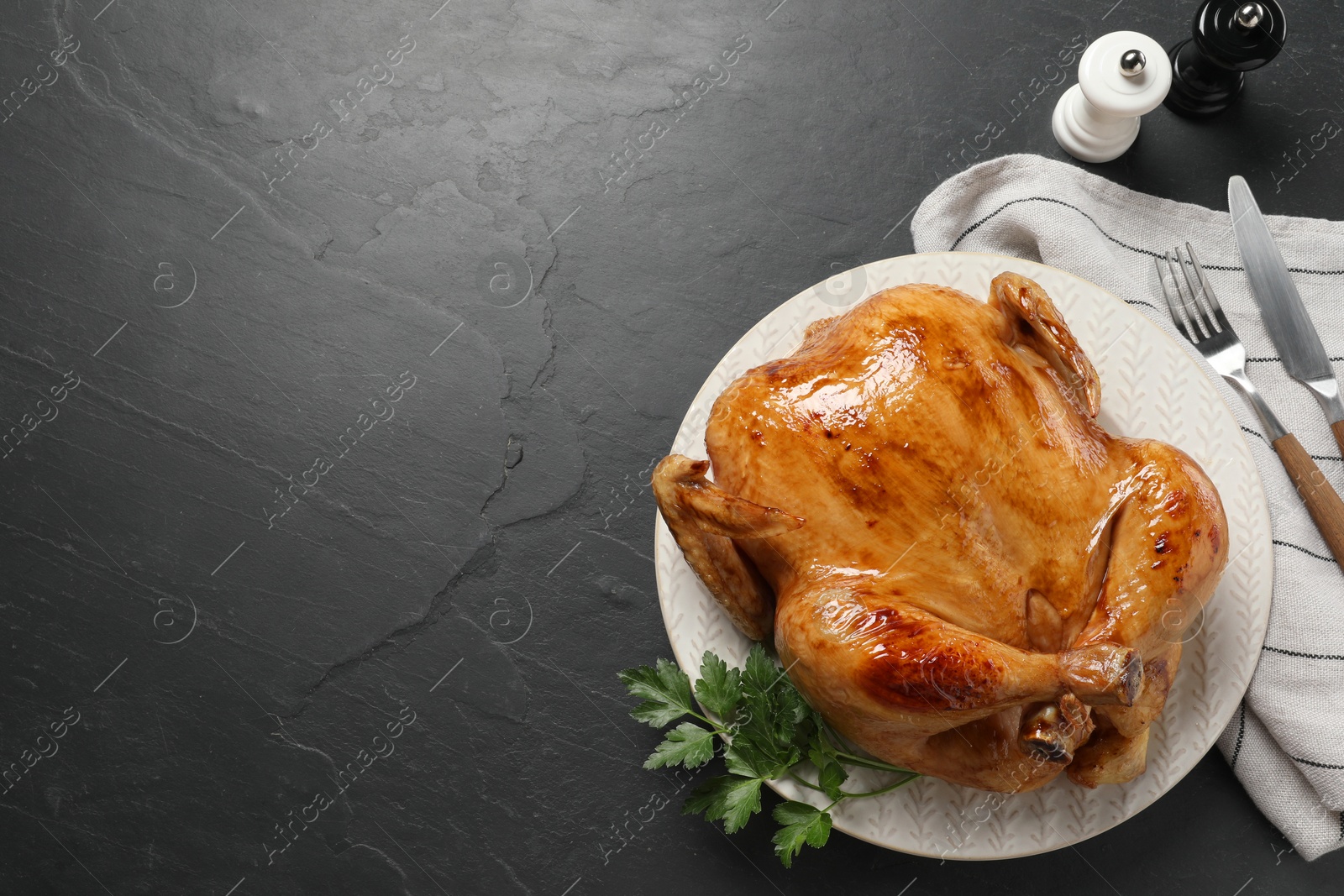 Photo of Tasty roasted chicken served on grey textured table, flat lay. Space for text