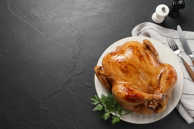 Tasty roasted chicken served on grey textured table, flat lay. Space for text