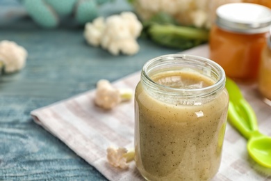 Photo of Jar with healthy baby food on table, closeup