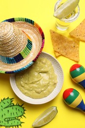 Flat lay composition with Mexican sombrero hat on yellow background