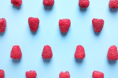 Photo of Fresh sweet ripe raspberries on light blue background, flat lay