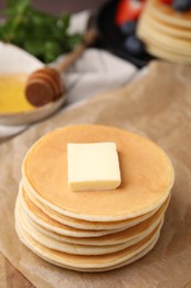 Delicious pancakes with butter on table, closeup