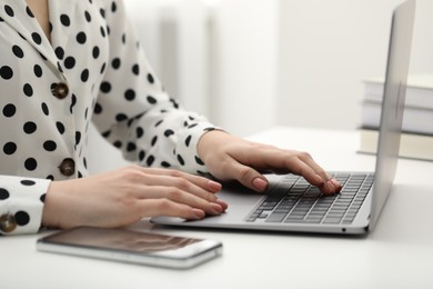 Photo of E-learning. Woman using laptop during online lesson at table indoors, closeup