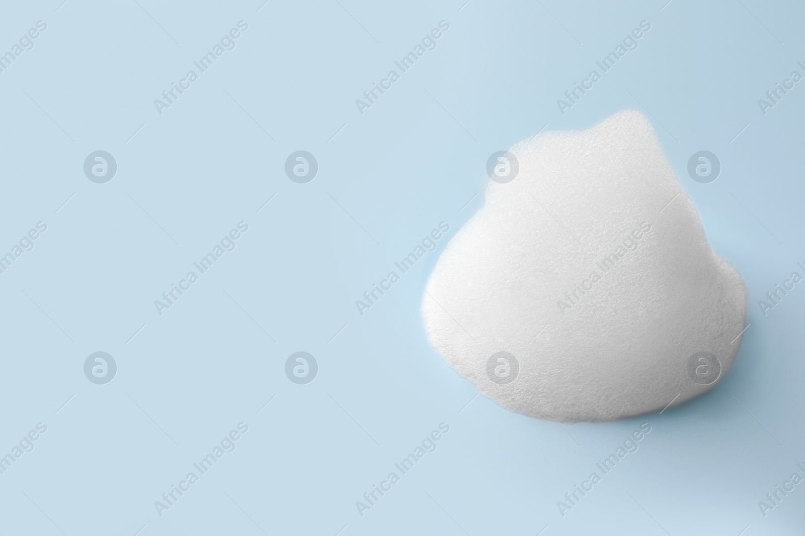 Photo of Foam sample on light blue background, space for text