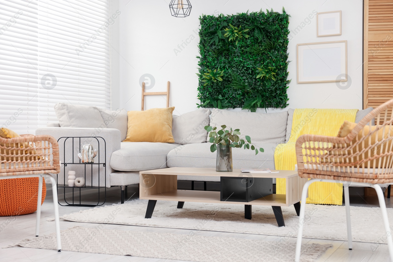 Photo of Green artificial plant wall panel and comfortable furniture in cozy living room. Interior design