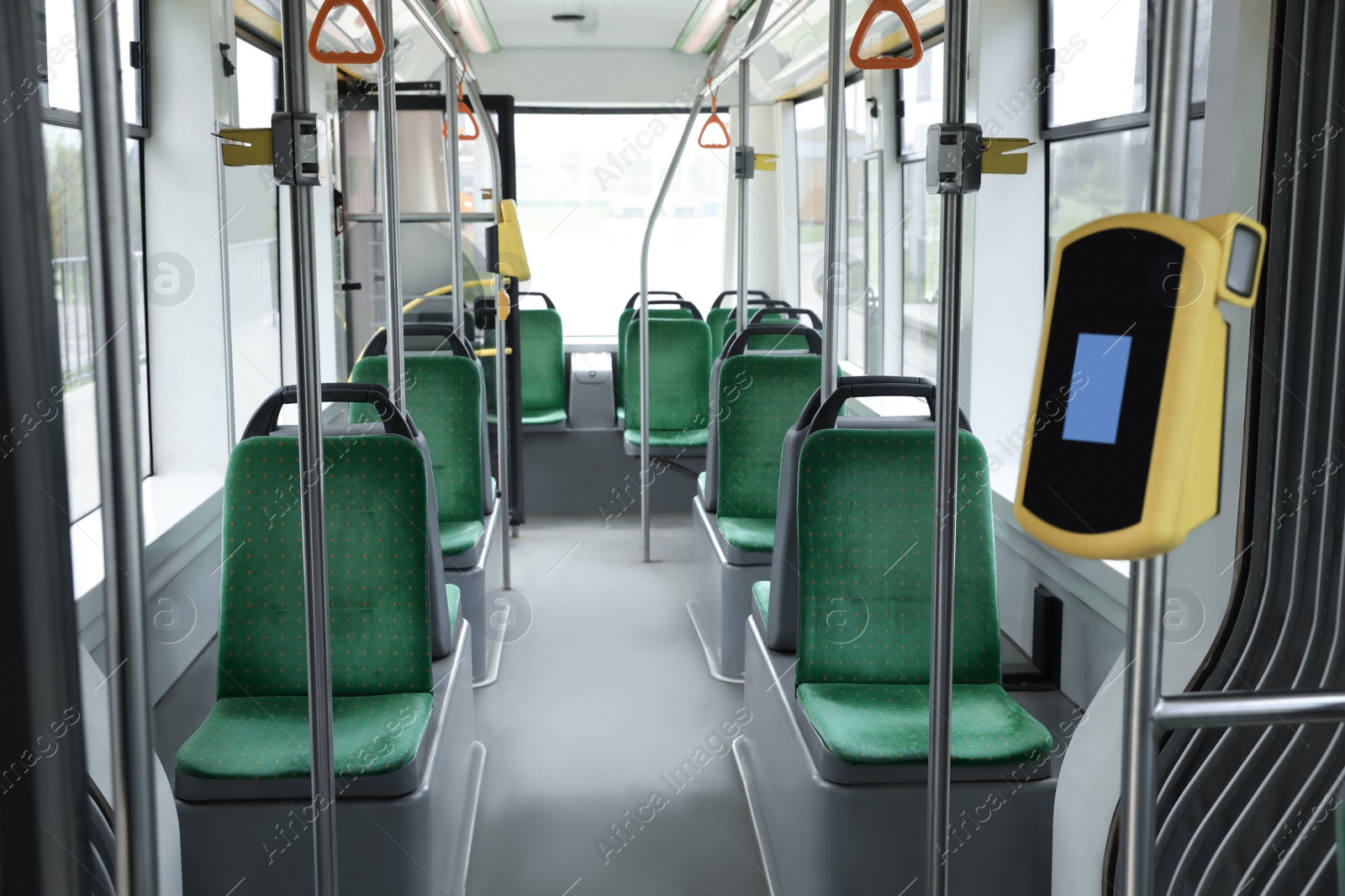 Photo of Public transport interior with comfortable green seats and contactless fare payment devices