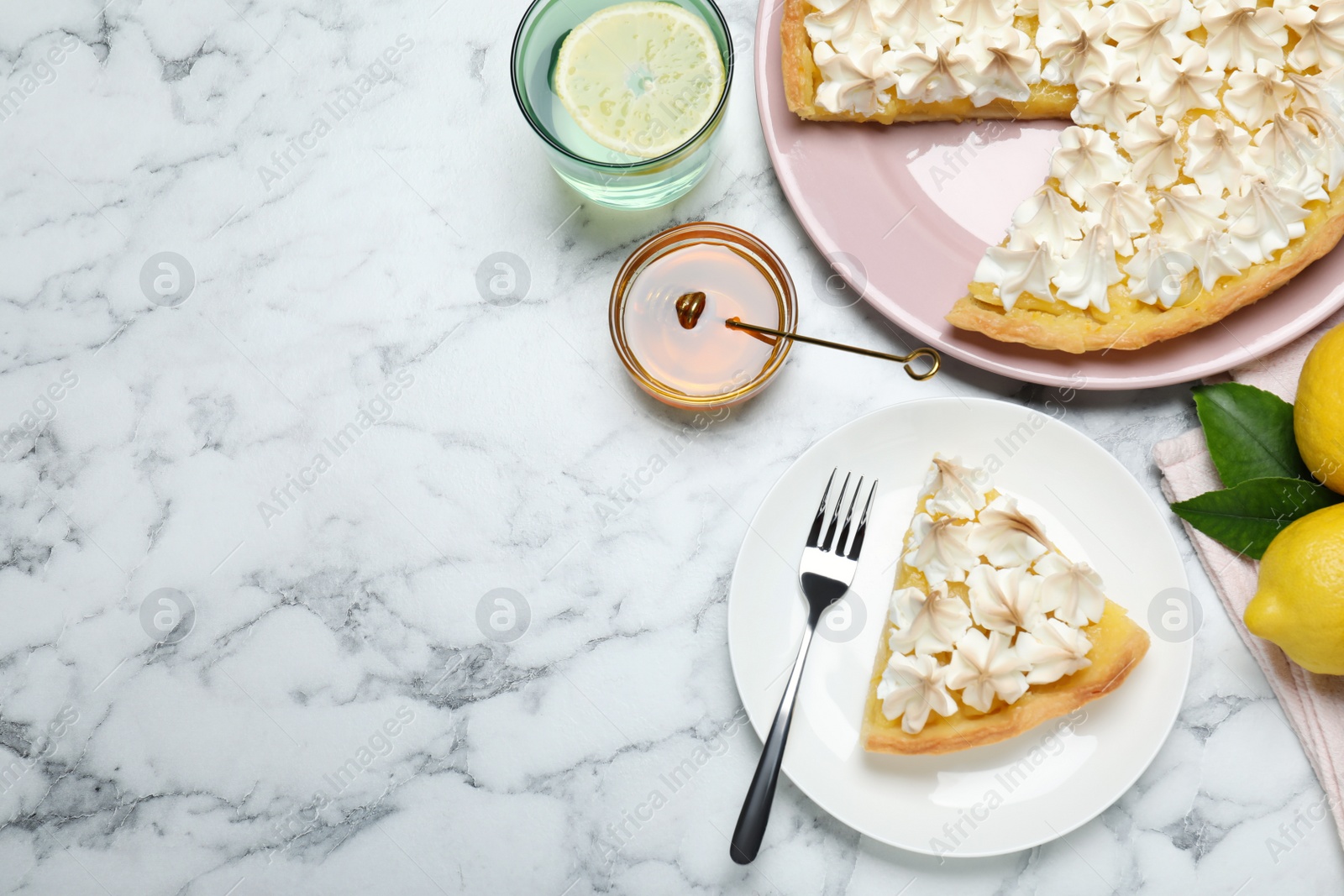 Photo of Cut delicious lemon meringue pie served on white marble table, flat lay. Space for text