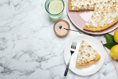 Cut delicious lemon meringue pie served on white marble table, flat lay. Space for text