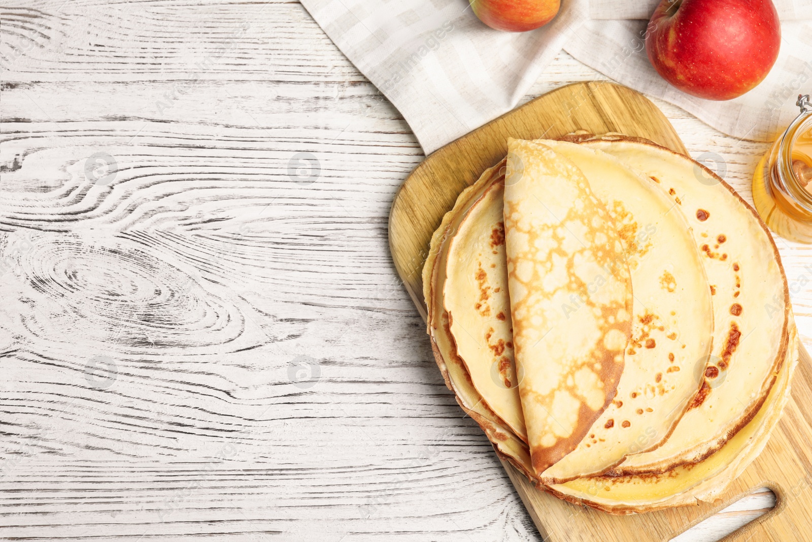 Photo of Flat lay composition with fresh thin pancakes on white wooden table table. Space for text