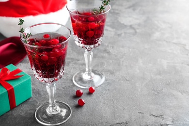 Photo of Delicious Christmas cocktail with liqueur on grey table. Space for text