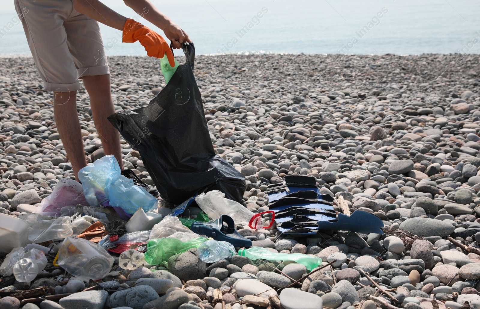 Photo of Man with trash bag collecting garbage in nature, closeup. Environmental Pollution concept