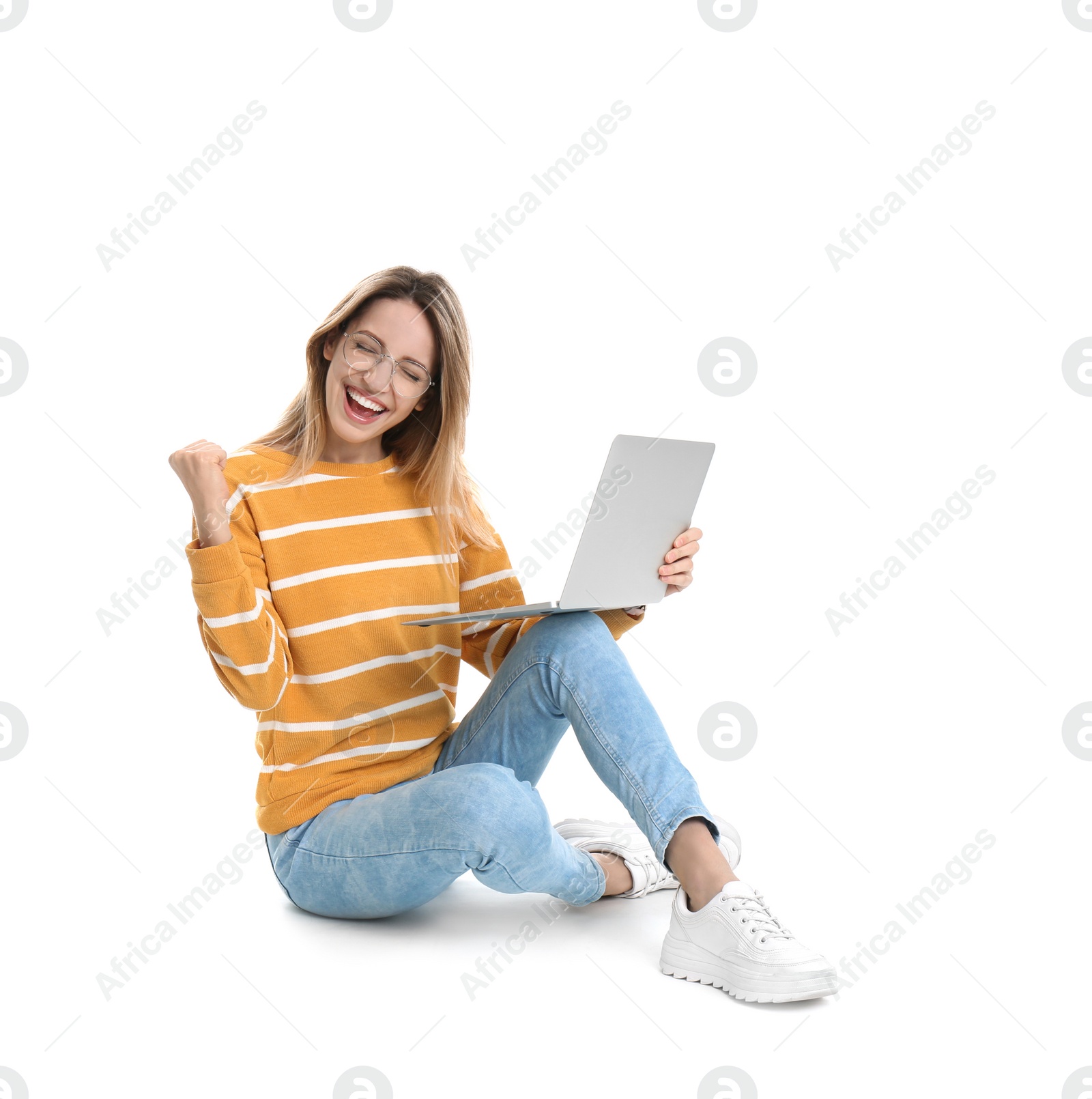 Photo of Happy young woman in casual outfit with laptop sitting on white background
