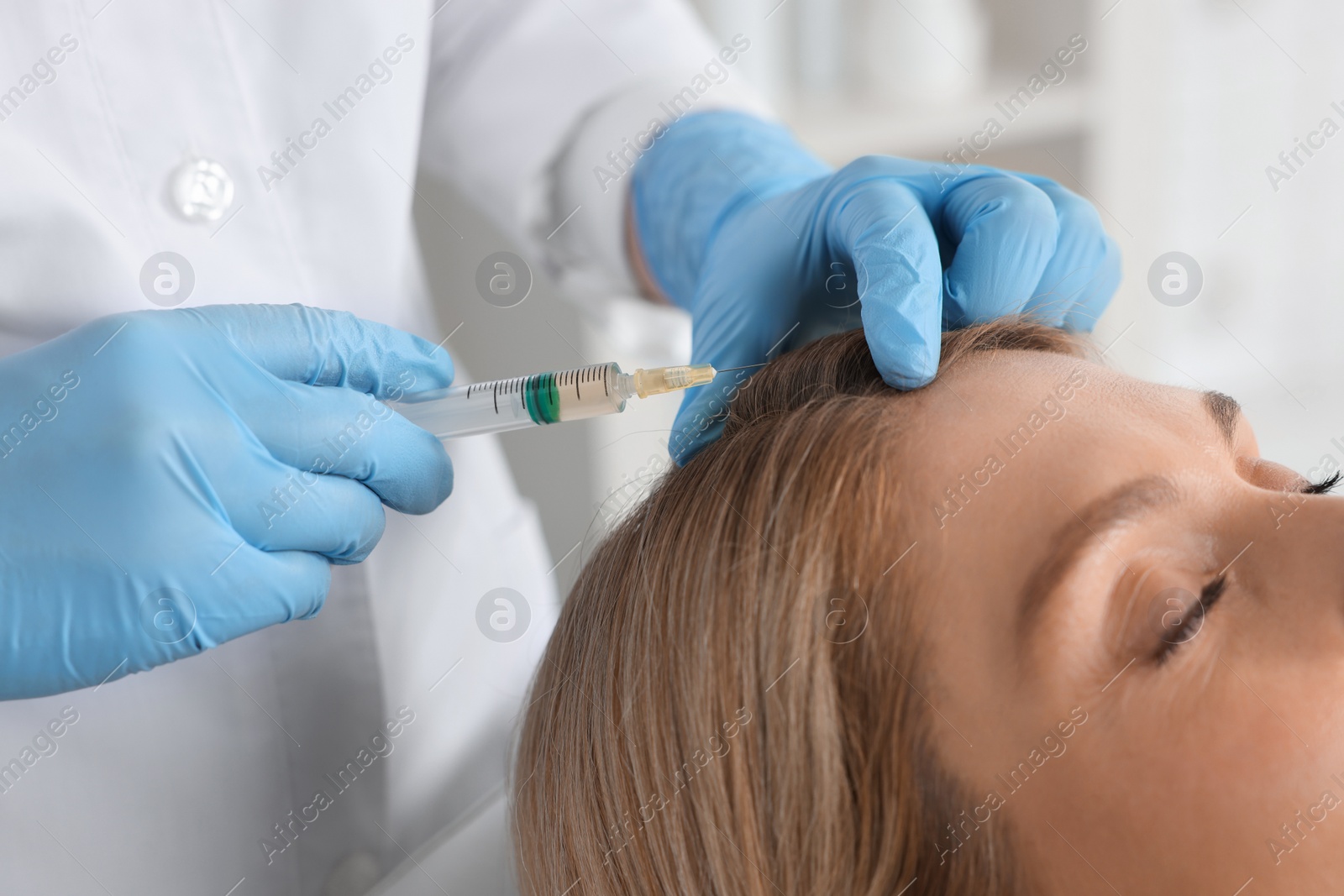 Photo of Trichologist giving injection to patient in clinic, closeup