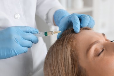 Trichologist giving injection to patient in clinic, closeup