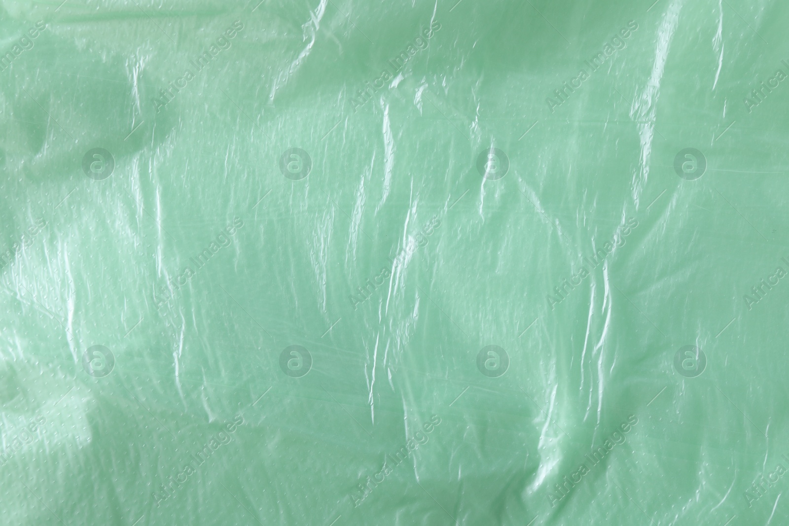 Photo of Texture of light green plastic bag as background, closeup