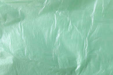 Texture of light green plastic bag as background, closeup