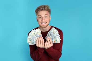 Photo of Young man with money on color background