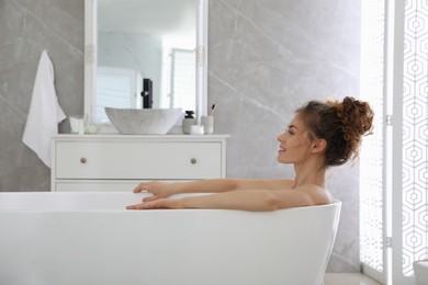 Photo of Beautiful woman relaxing in bathtub at home