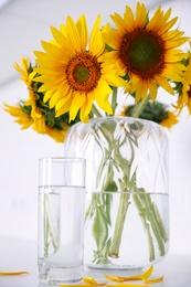 Bouquet of beautiful sunflowers on light table, closeup