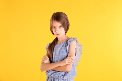 Photo of Portrait of cute little girl on yellow background