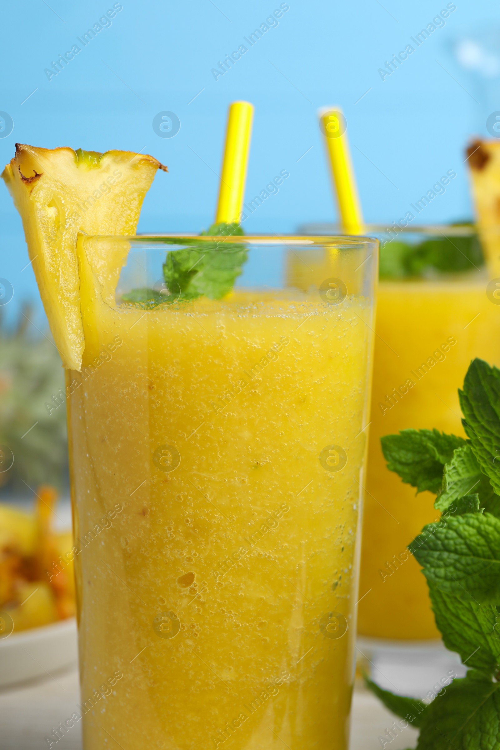 Photo of Tasty pineapple smoothie and mint on table, closeup