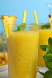 Photo of Tasty pineapple smoothie and mint on table, closeup