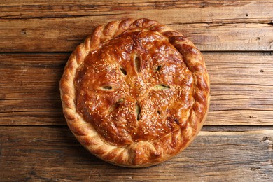 Tasty homemade pie with filling on wooden table, top view