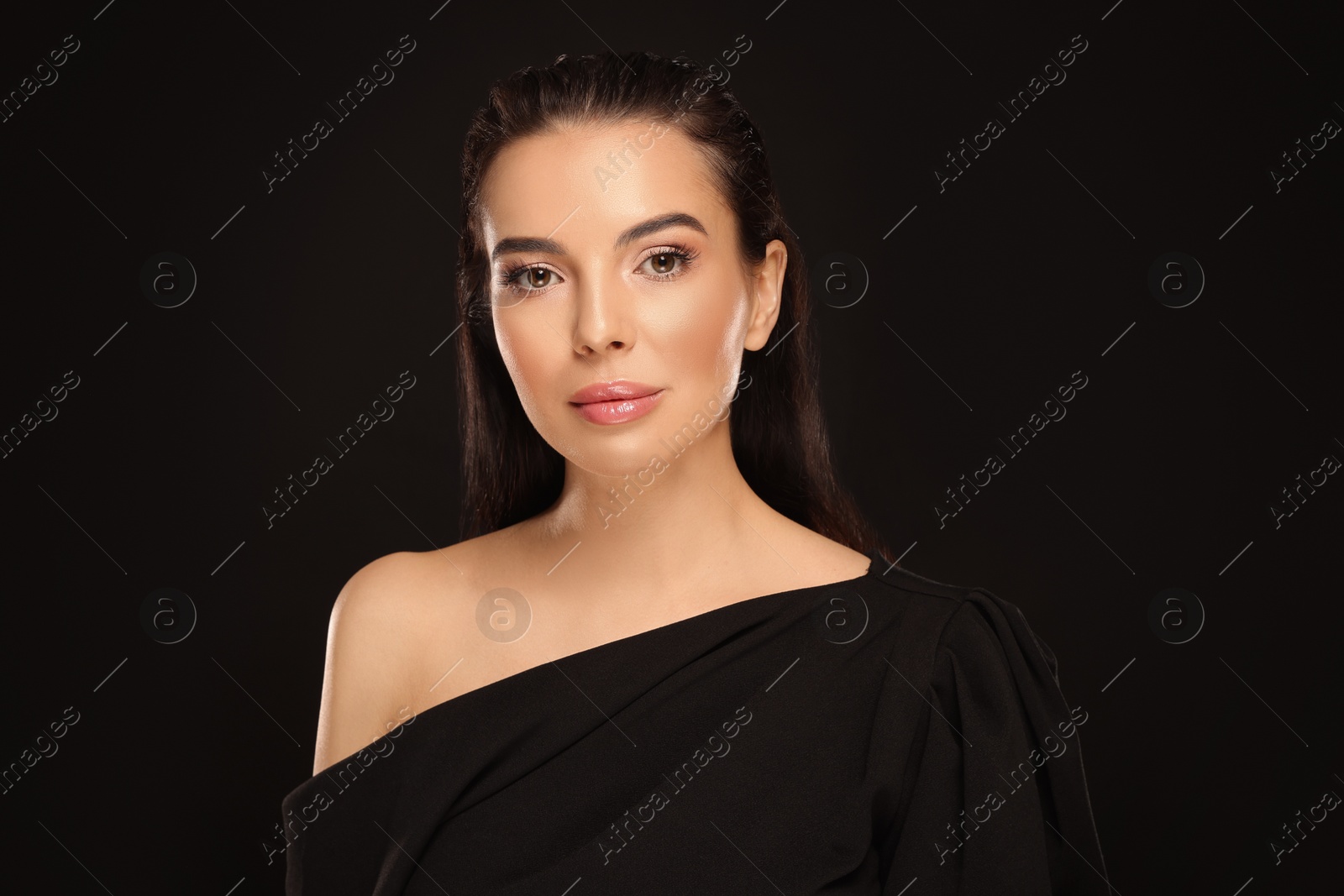 Photo of Portrait of young woman with beautiful makeup on black background