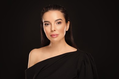 Photo of Portrait of young woman with beautiful makeup on black background
