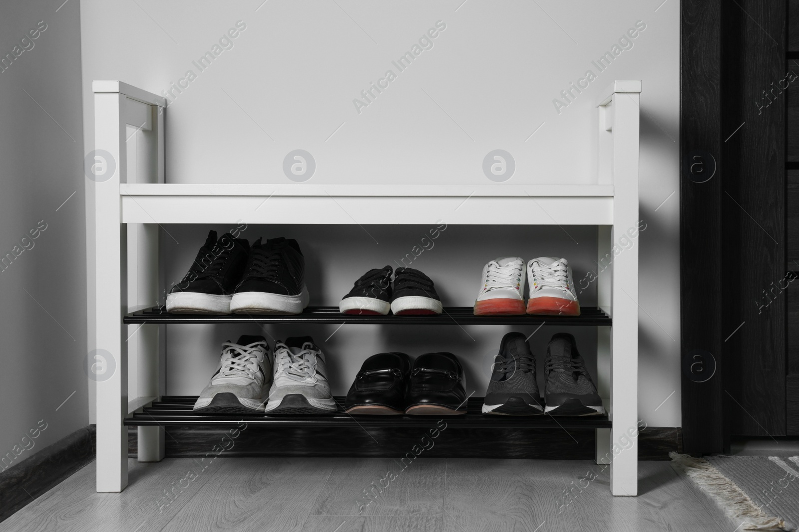 Photo of Shoe storage bench near white wall in hallway. Interior design