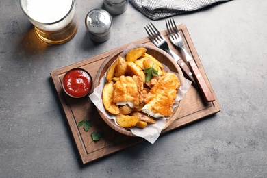 Photo of Tasty British traditional fish and potato chips on table, top view