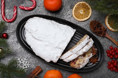 Traditional Christmas Stollen with icing sugar on grey table, flat lay