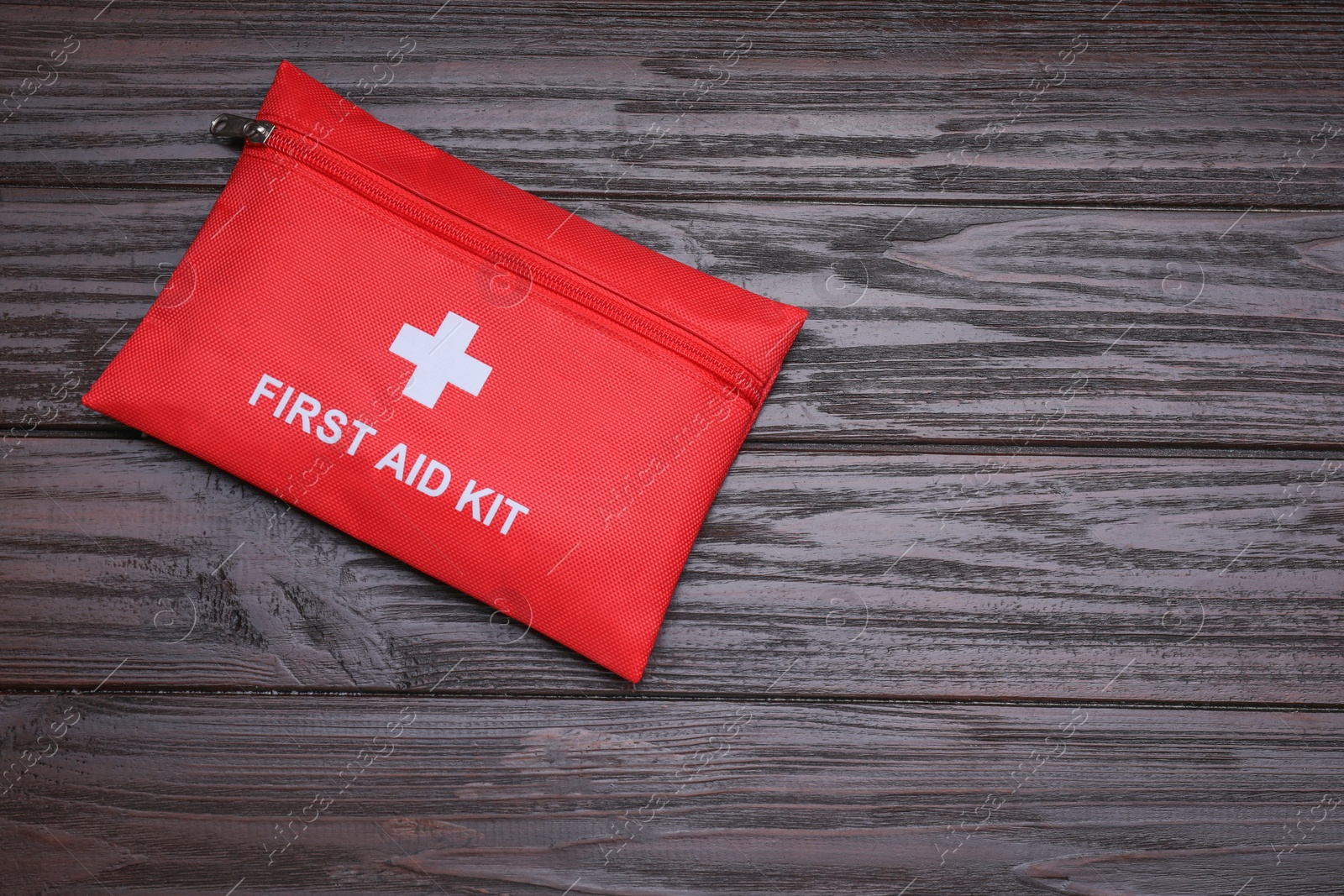 Photo of Medicine bag on wooden table, top view with space for text. First aid kit